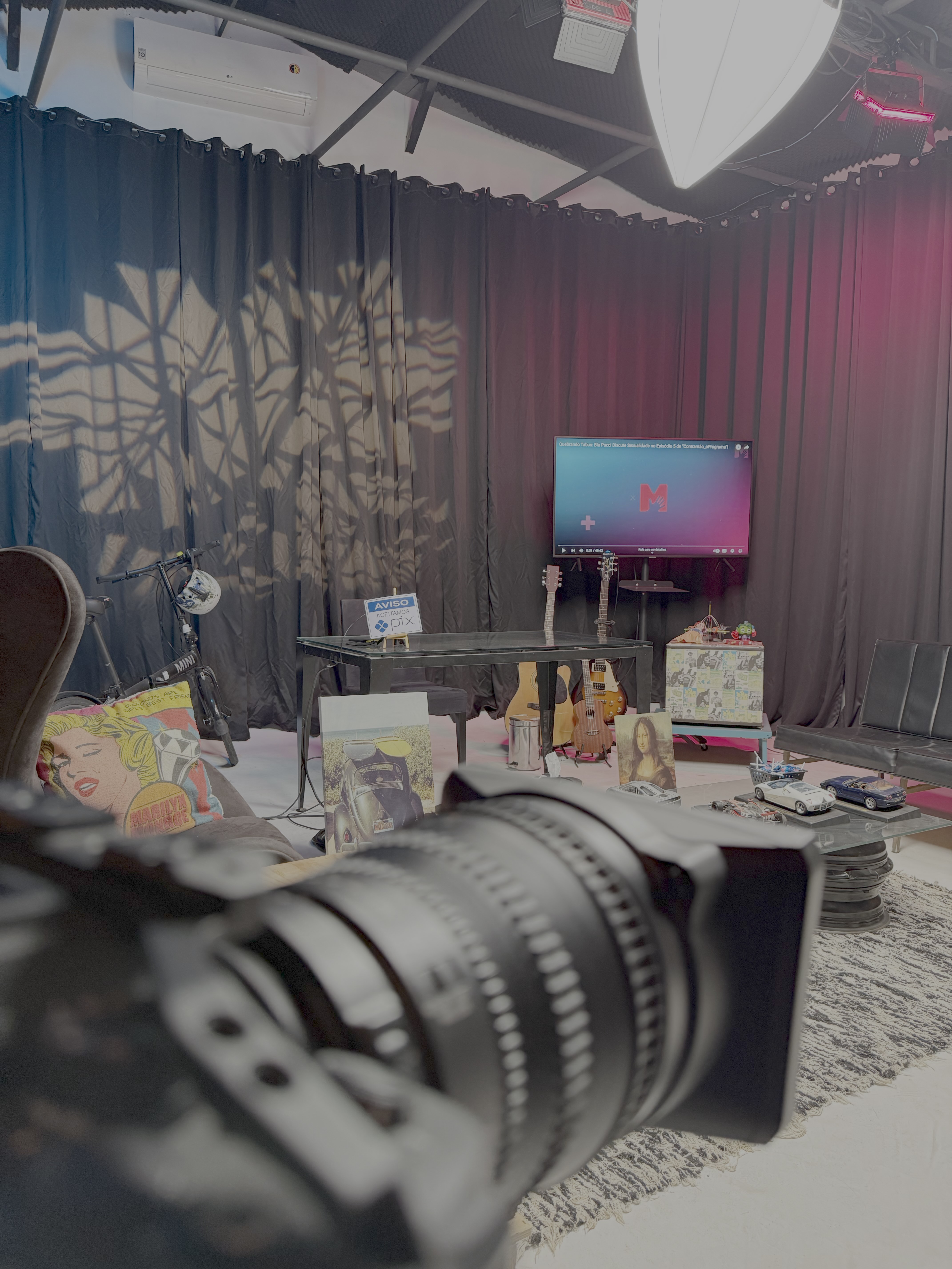 Room with a TV screen, table setup, and camera lens in the foreground